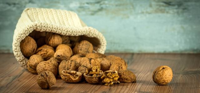 Small sack of walnuts on a wooden floor